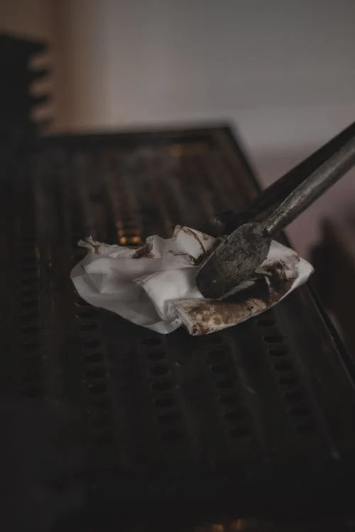 Close-up shot of a person cleaning a barbecue grill