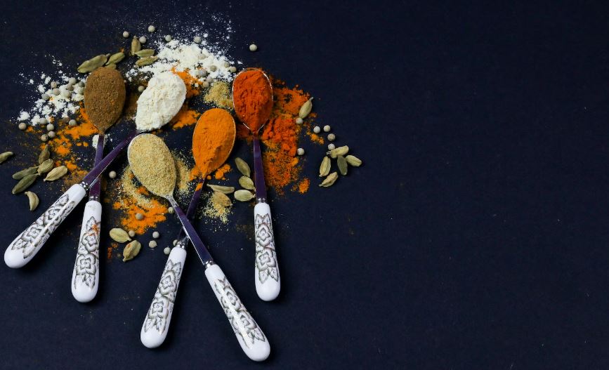 Colorful various herbs and spices for cooking on dark background