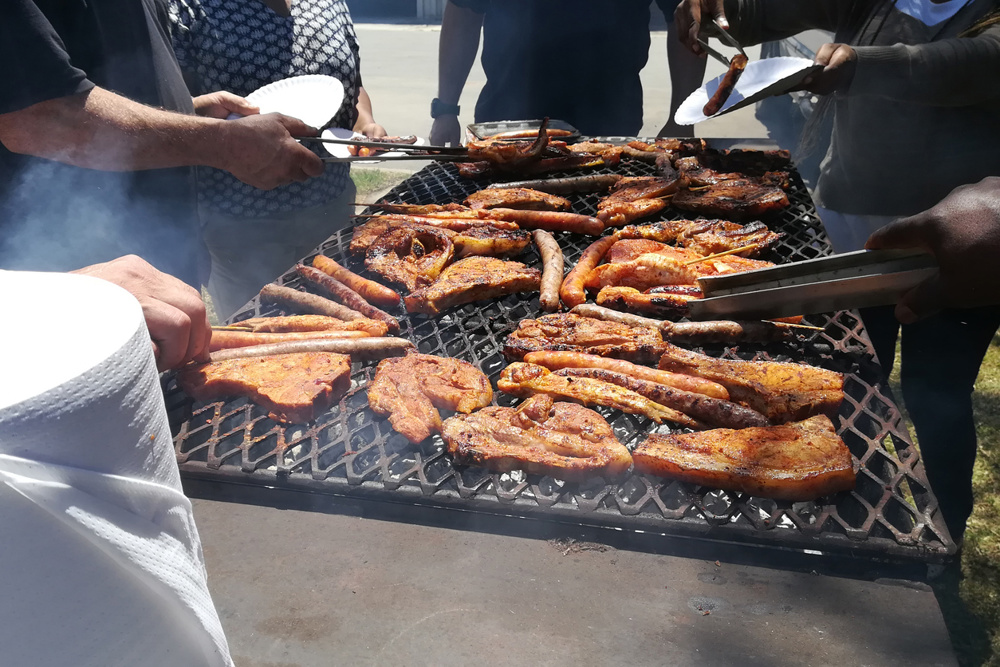 South African people braaing (cooking) meat together. Diversity concept image