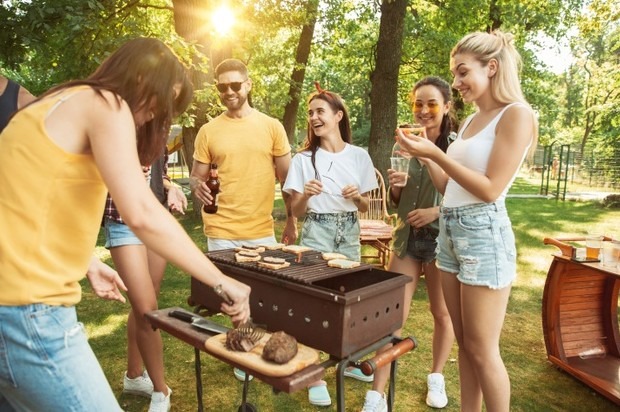 a group of people having a BBQ party outdoors