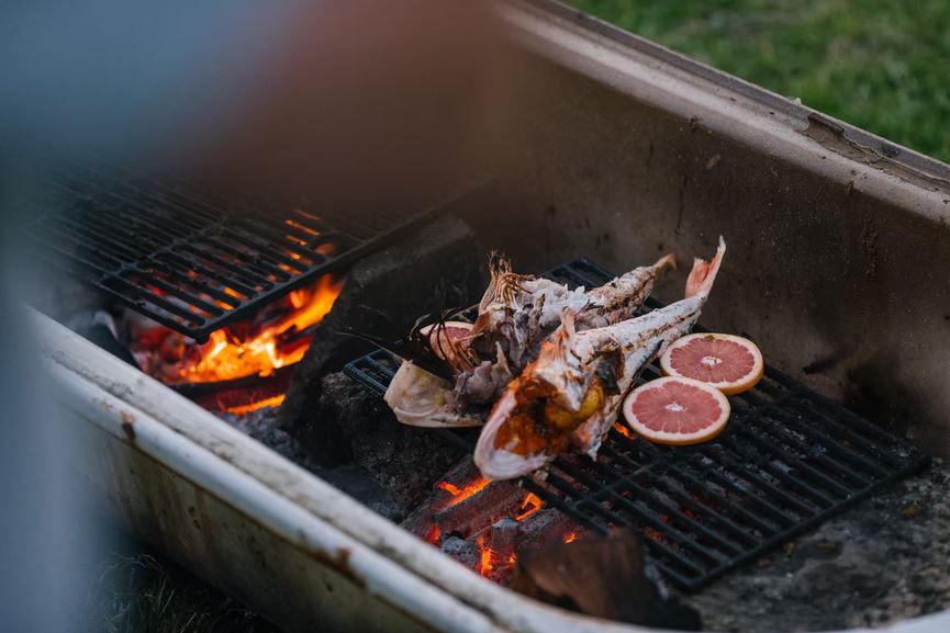 Fish being grilled on a charcoal grill