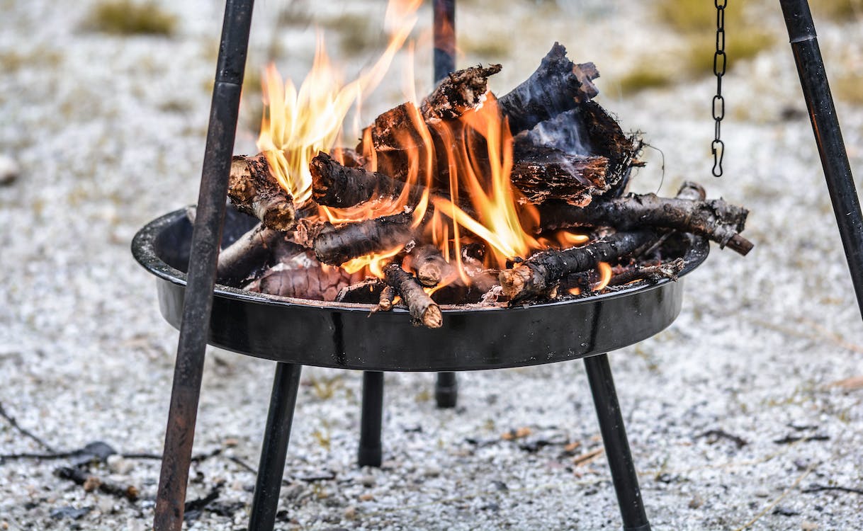 Firewood burning in black steel round tray